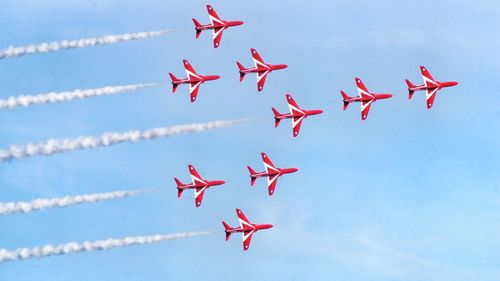 Low angle view of airshow against sky