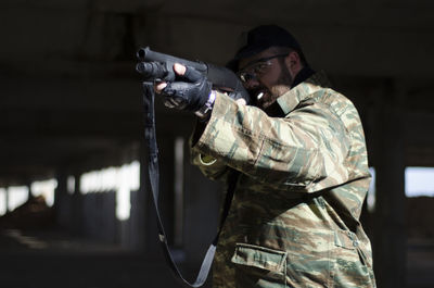 Army soldier shooting with machine gun in basement