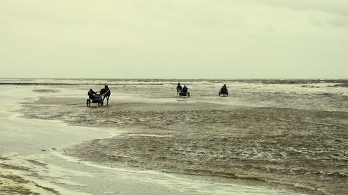 People on beach against sky