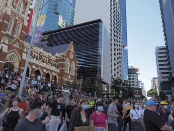 People on street amidst buildings in city