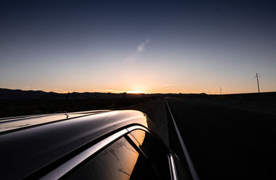 Car on road against sky during sunset