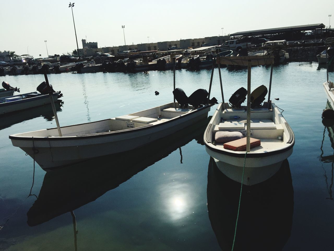 nautical vessel, water, moored, boat, transportation, mode of transport, reflection, harbor, waterfront, sky, river, clear sky, sea, outdoors, building exterior, built structure, architecture, no people, day, yacht