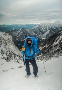 Full length of man standing on snowcapped mountain