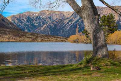 Scenic view of lake by mountains against sky