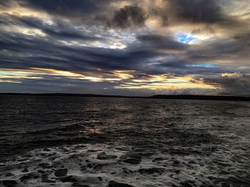 Scenic view of beach against dramatic sky