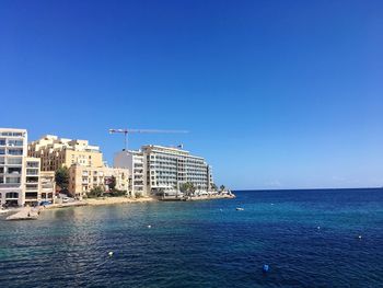 Sea in front of seascape against clear blue sky