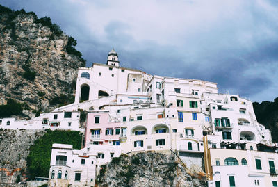 Buildings in town against cloudy sky