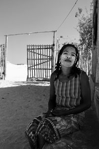 Young woman standing against the sky