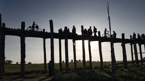 Silhouette people on field against clear sky
