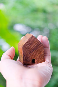 Close-up of hand holding house shaped wood