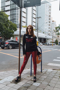 Portrait of teenage girl standing on road in city