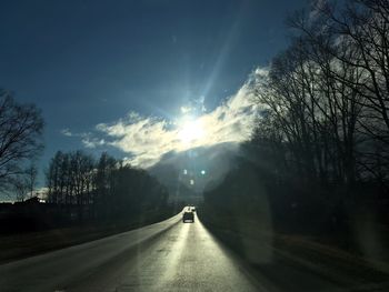 Road amidst trees against sky