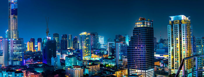 Illuminated buildings in city against sky