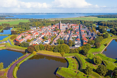 High angle view of river amidst buildings against sky