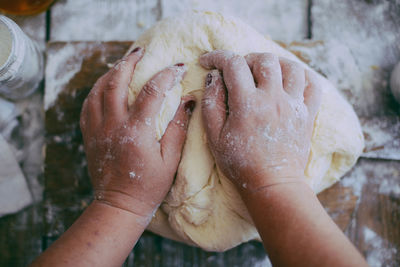 Close-up of hands kneading dough