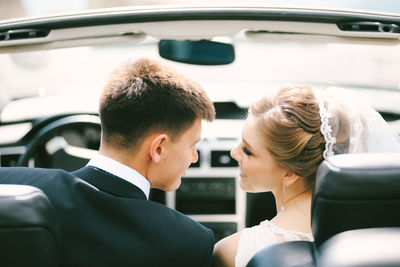 Portrait of smiling couple sitting in car