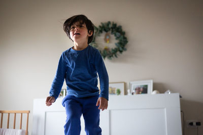 Jumping on the bed child in blue pyjamas