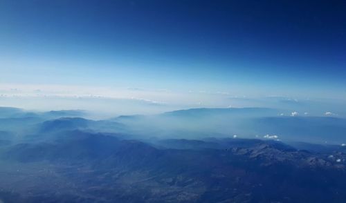 Scenic view of mountains against blue sky