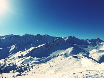 Scenic view of snowcapped mountains against clear blue sky