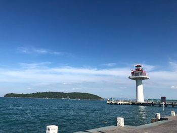 Lighthouse by sea against sky