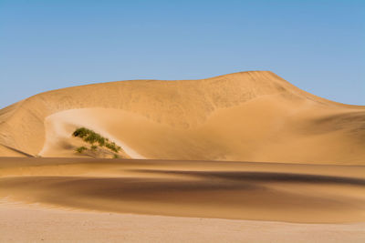 Scenic view of desert against clear blue sky