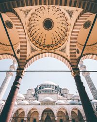 Low angle view of religious building seen through arch against sky