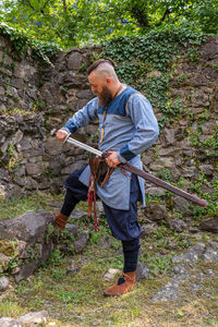 Full length of man holding umbrella in forest