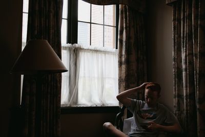 Man using phone while sitting on chair at home