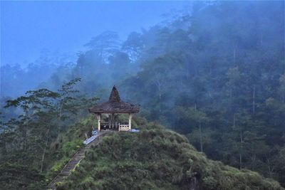 View of temple against building and mountain