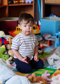 Cute baby boy playing with toys at home