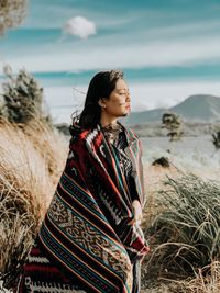 Woman standing at beach against sky