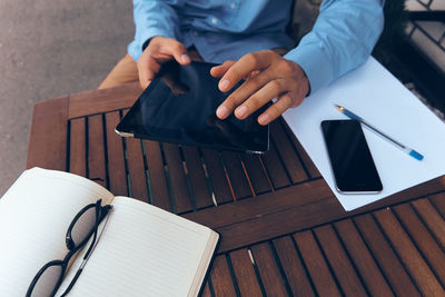 High angle view of man using mobile phone on table