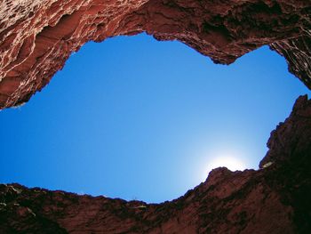 Low angle view of rock formation against clear blue sky