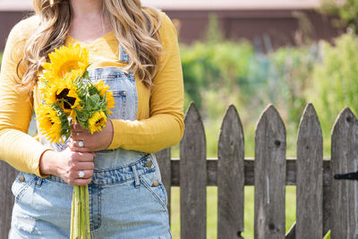 Close-up of woman holding yellow flower