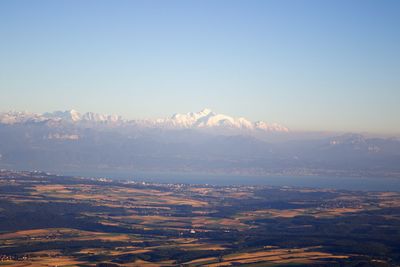 Aerial view of city by sea against sky