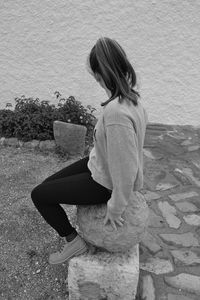 Side view of young woman sitting outdoors