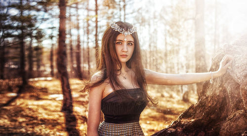 Portrait of beautiful young woman standing in forest