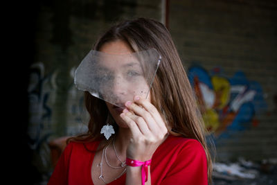 Portrait of beautiful woman looking through broken glass