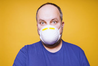 Portrait of man wearing hat against yellow background