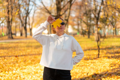 Man with umbrella standing on field during autumn