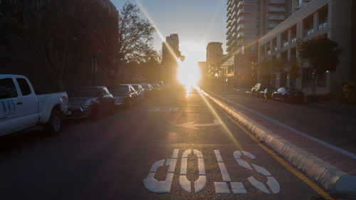 Stop sign on road in city at sunset