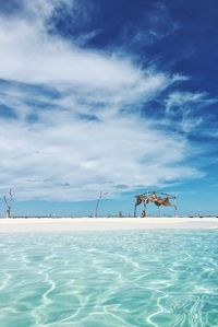 Swimming pool by sea against sky