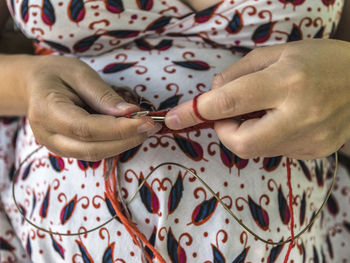 Midsection of woman knitting wool