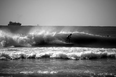 Person surfing on waves at sea