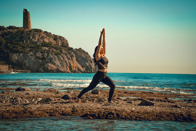 Rear view of woman standing at beach