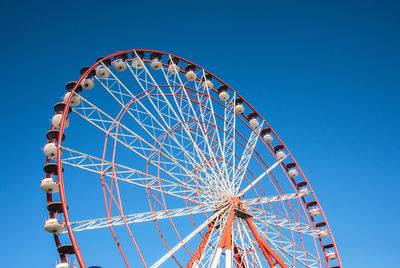 Low angle view of ferris wheel against blue sky