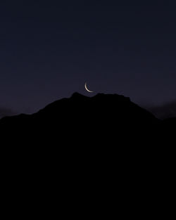 Low angle view of silhouette mountain against sky at night