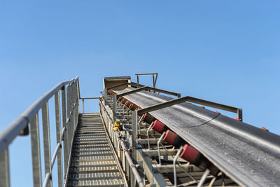 Close-up shot of the conveyor belt in the concrete plant with transport rollers, metal stairs