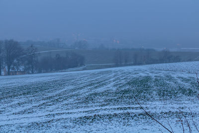 Scenic view of snow covered land against sky