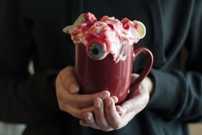 Woman holding mug with halloween drink